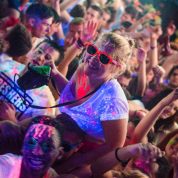 girl on shoulders in nightclub getting splattered in uv paint